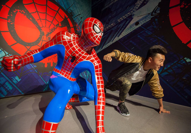 A visitor poses for photos with a wax figure of Spiderman in the movie series "Spider-Man" at a new wax figure museum in Hohhot city, north China's Inner Mongolia Autonomous Region, 5 June 2018. - Photo, image