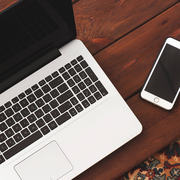 Laptop and phone on wooden background - Zdjęcie, obraz