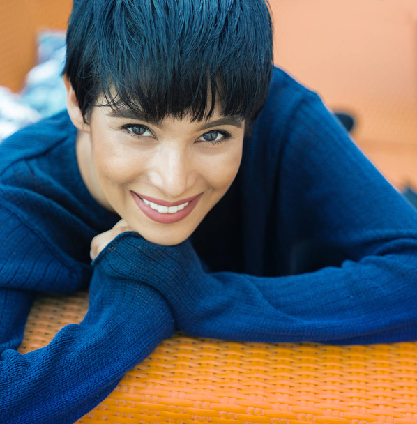 Carefree relaxed pretty woman with short hair blue and orange, warm and cool tones. - Fotoğraf, Görsel