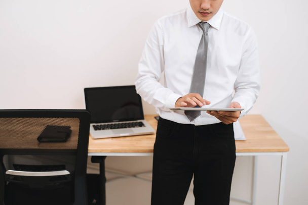 Homme d'affaires inconnu tenant tablette numérique dans le bureau
 - Photo, image