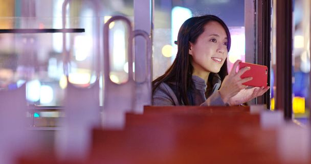 Tourist Woman prendre des photos avec smartphone sur le tramway à Hong Kong la nuit
 - Photo, image