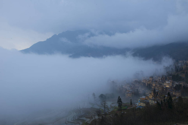Τοπίο στους ορυζώνες του Yuanyang ρύζι βεράντες στην πρωινή ομίχλη στην κομητεία Yuanyang, Honghe Χάνι και Yi αυτόνομη Νομός, επαρχία Yunnan της νοτιοδυτικής Κίνας, 27 Φεβρουαρίου 2018. - Φωτογραφία, εικόνα