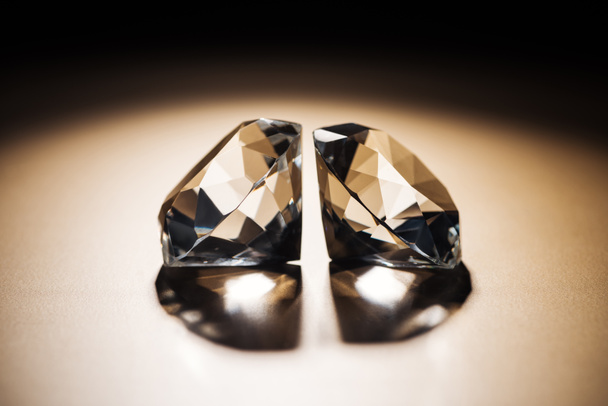 two clear big diamonds on black and golden background - Foto, afbeelding