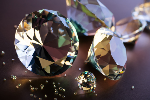Close up van grote en kleine diamanten op bruine achtergrond - Foto, afbeelding