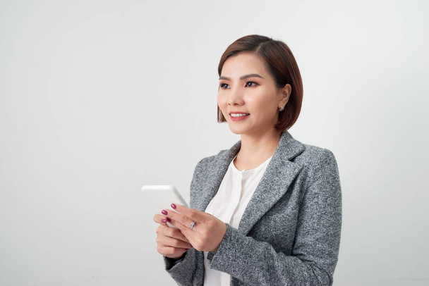 Улыбающаяся деловая женщина с помощью смартфона на белом фоне
 - Фото, изображение