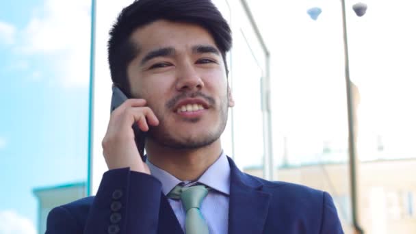 Portrait of talking by smartphone asian man - Materiał filmowy, wideo