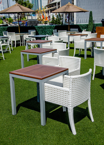 Вид на улицу с кофейной террасы со столами и стульями
 - Фото, изображение