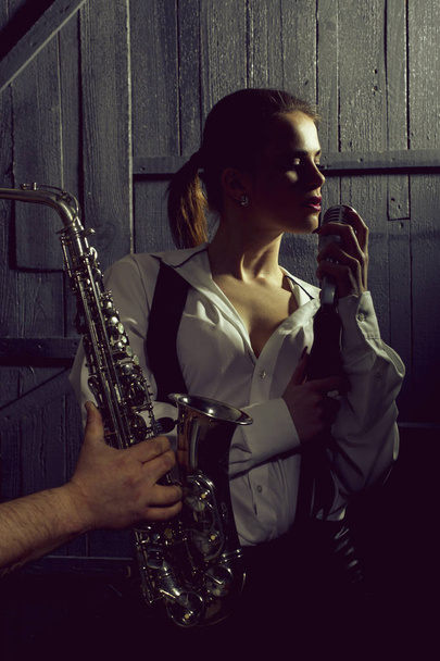 woman with microphone and man with sax - Foto, Imagem