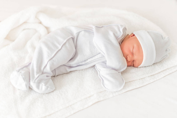 Sleepy baby close-up in a baby cot. - 写真・画像