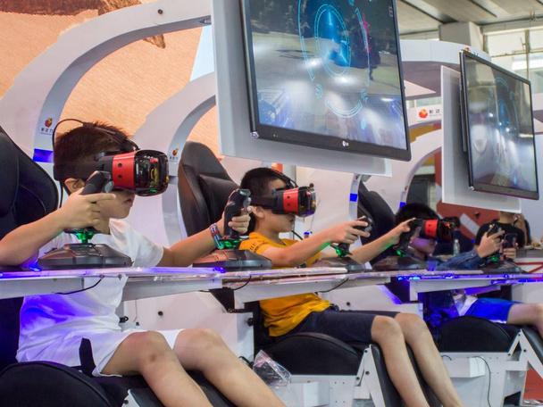 Китайские дети используют виртуальную реальность (VR) устройства для игры во время выставки 2018 года в городе Гуанчжоу, провинция Гуандун, 3 апреля 2018 года
 - Фото, изображение