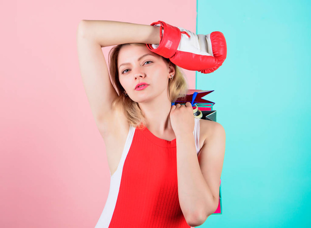 Woman red boxing glove hold bunch shopping bags blue pink background. Tips to shop sales. Buy everything you want. Girl tired with shopping. Fight for personal discount. Survive black friday shopping - 写真・画像