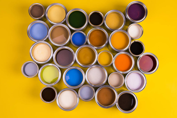Baldes cheios de tinta a óleo de cor arco-íris no fundo amarelo
 - Foto, Imagem