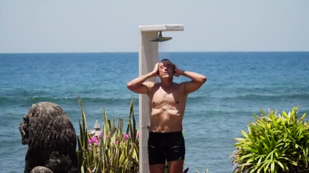 man en douche op het strand - Video