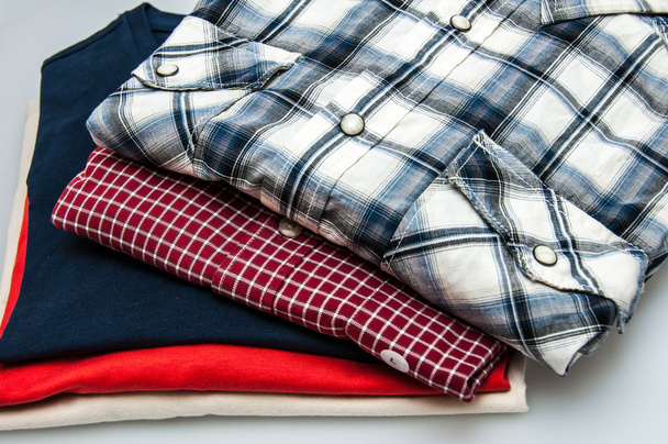 Montón de Camisetas y Camisetas en diferentes colores aislados en blanco
 - Foto, Imagen