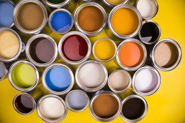 Paleta de colores de latas de pintura, fondo amarillo
 - Foto, imagen