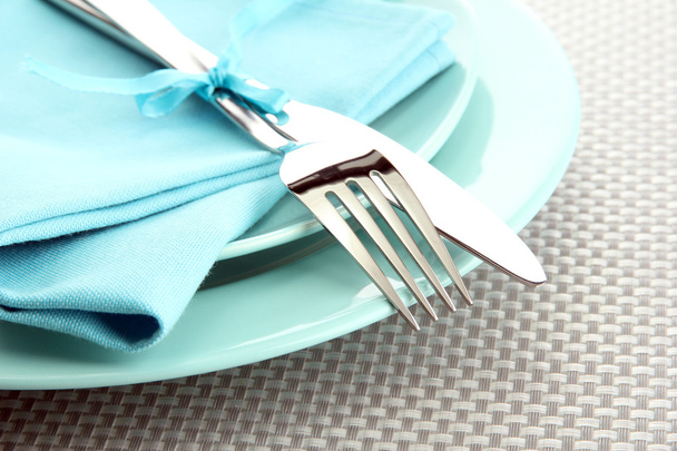 blue empty plates with fork and knife on a grey tablecloth - Fotoğraf, Görsel