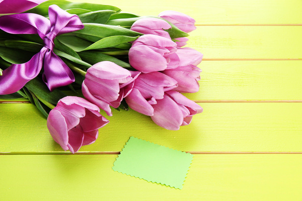 Beautiful bouquet of purple tulips on green wooden background - Фото, изображение