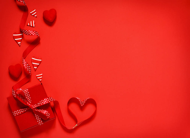Sevgililer günü, kopya alanı için kırmızı zemin üzerine kırmızı yay kurdele ile hediye kutusu - Fotoğraf, Görsel