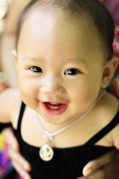 das Gesicht eines kleinen Kindes lächelt glücklich. - Foto, Bild