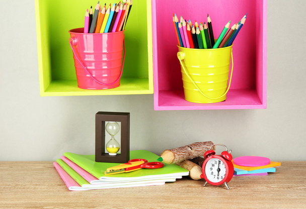 Colorful pencils in pails on shelves on beige background - Фото, изображение