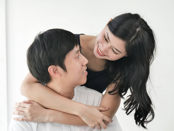 Romantic Asian couple hug and kissing near window at home, lifestyle concept. - Foto, Imagen
