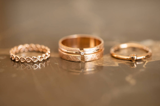 Siempre juntos anillos de corazón de boda en la mesa de mármol de oro, simbolizan el amor y permanecer juntos para siempre, macro
 - Foto, imagen