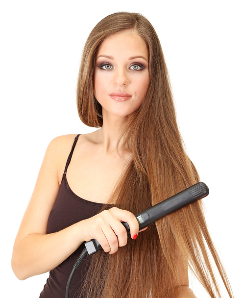 Woman doing hairstyle with hair straightener, isolated on white - Foto, immagini