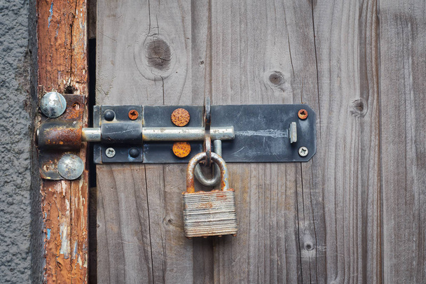 ドアが木製の古い錆びた南京錠。Olose. - 写真・画像