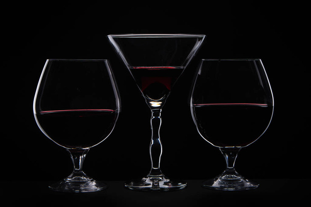 Üç siyah arka plan üzerine cam ile kırmızı şarap içme silüeti  - Fotoğraf, Görsel