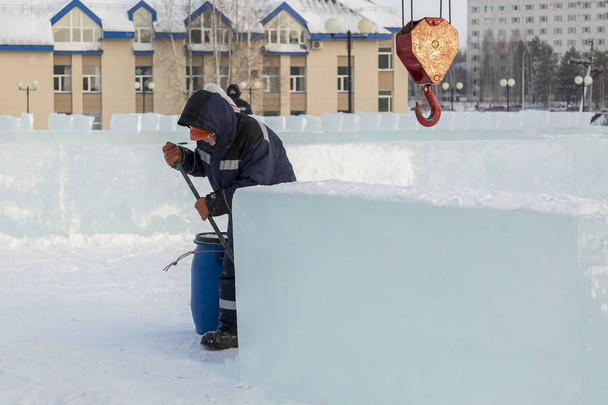 Portret pracownika zajmującego się montażem bloku lodowego na lodowym miasteczku - Zdjęcie, obraz