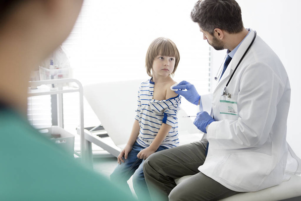 pediatrician vaccinating little patient in hospital - Фото, изображение