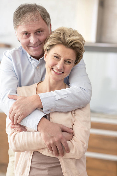 Portrait happy mature couple standing at home - Fotó, kép