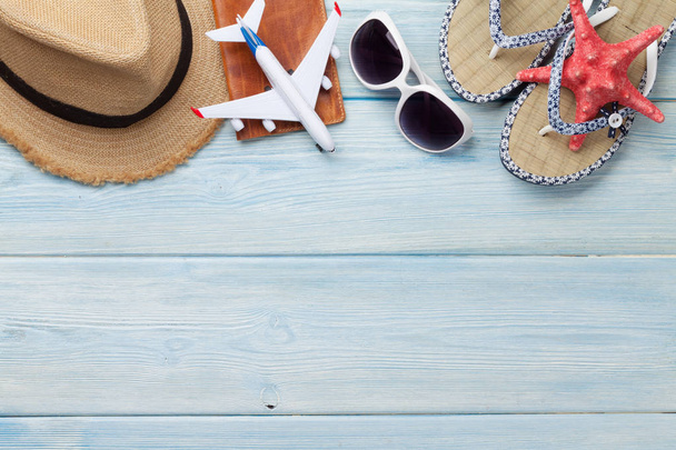 Travel vacation background concept with sun hat. sunglasses, passport, airplane toy and starfish on wooden backdrop. Top view with copy space. Flat lay - Photo, Image