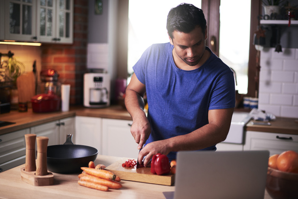 Muž řezání zelenina v kuchyni  - Fotografie, Obrázek
