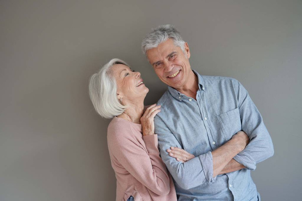  Lovely portrait of attractive senior couple on grey background                               - 写真・画像
