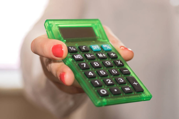 Egy nő egy számológép tartja a kezét - Fotó, kép