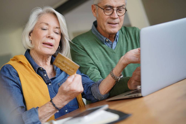 Happy senior couple online shopping at home                               - Foto, immagini