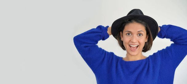 Isolated vibrant playful stunning brunette in hat looking at camera - Foto, Imagen