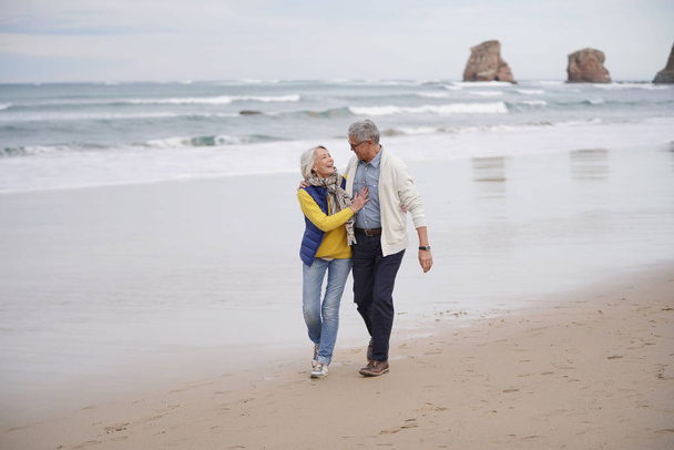  Ευτυχισμένο ζευγάρι ανώτερος περπάτημα μαζί στην παραλία                               - Φωτογραφία, εικόνα