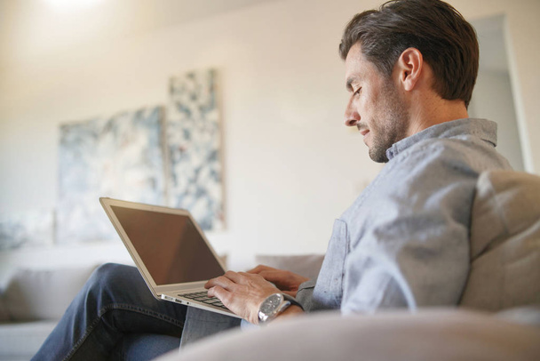  Handsome caucasian man with computer in modern home                              - Foto, Imagem