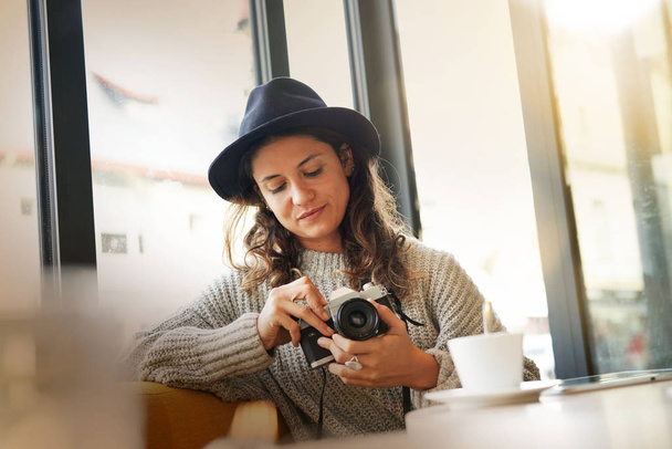 Beautiful brunette in modern cafe with vintage camera - Foto, afbeelding