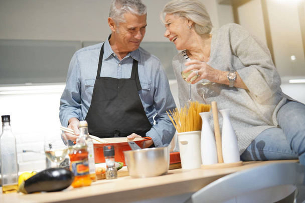  Senior couple couple cooking together in modern kitchen                               - Photo, Image