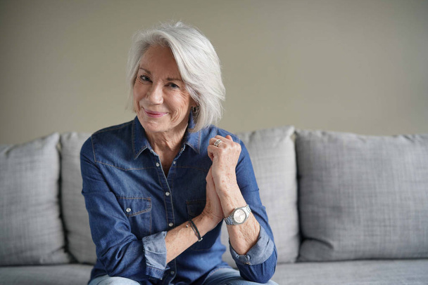 Portrait of modern senior woman in all denim on couch                               - Photo, Image