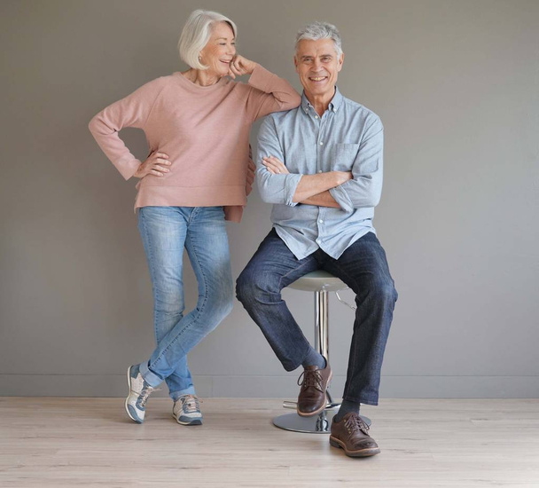  Full length of happy senior couple on grey background                               - Foto, afbeelding