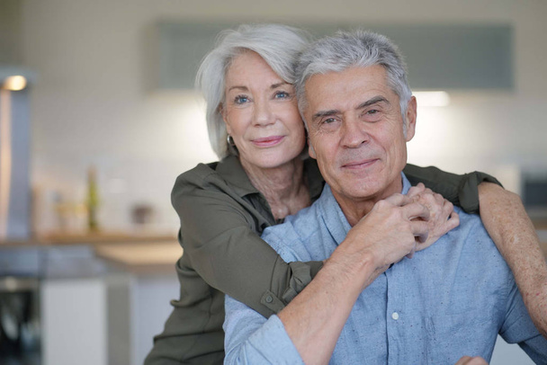  Portrait of loving senior couple in modern home                               - Фото, изображение