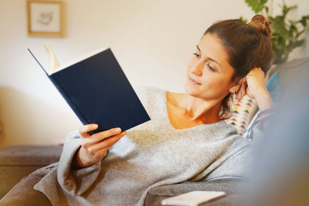 Příležitostné mladá žena čtení knihy doma - Fotografie, Obrázek