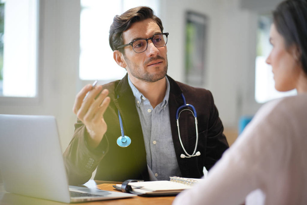 Modern young doctor speaking to patient in office                               - Photo, Image