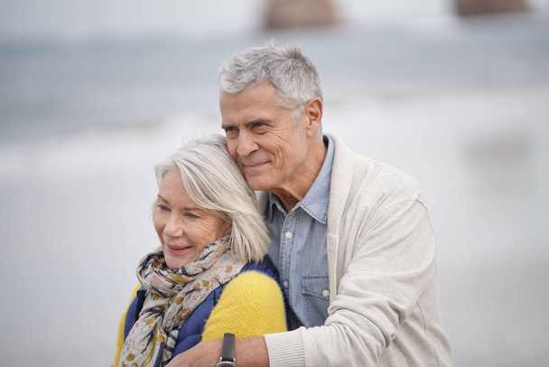  Portrait of happy senior couple embracing on the beach                               - Fotó, kép