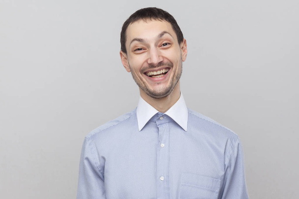 Portrait of happy satisfied businessman looking at camera with funny face on grey background - Fotoğraf, Görsel