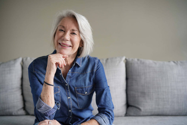  Portrait of modern senior woman in all denim on couch                               - Photo, Image